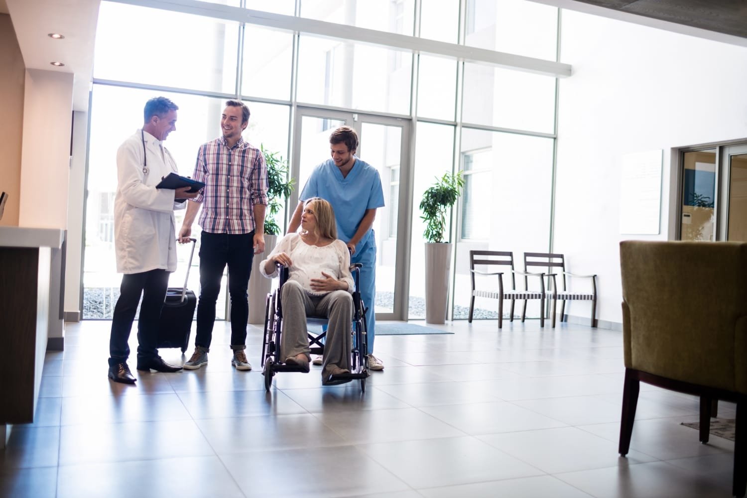 Mujer embarazada ingresando a clínica en silla de ruedas